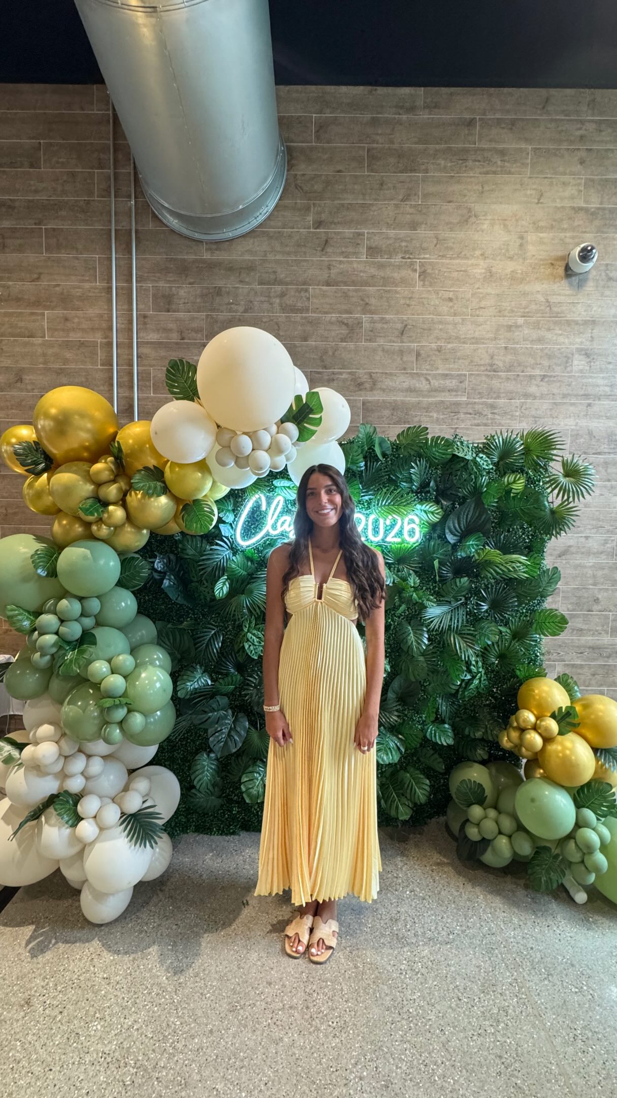 Tropical green graduation balloon backdrop with layered palm details