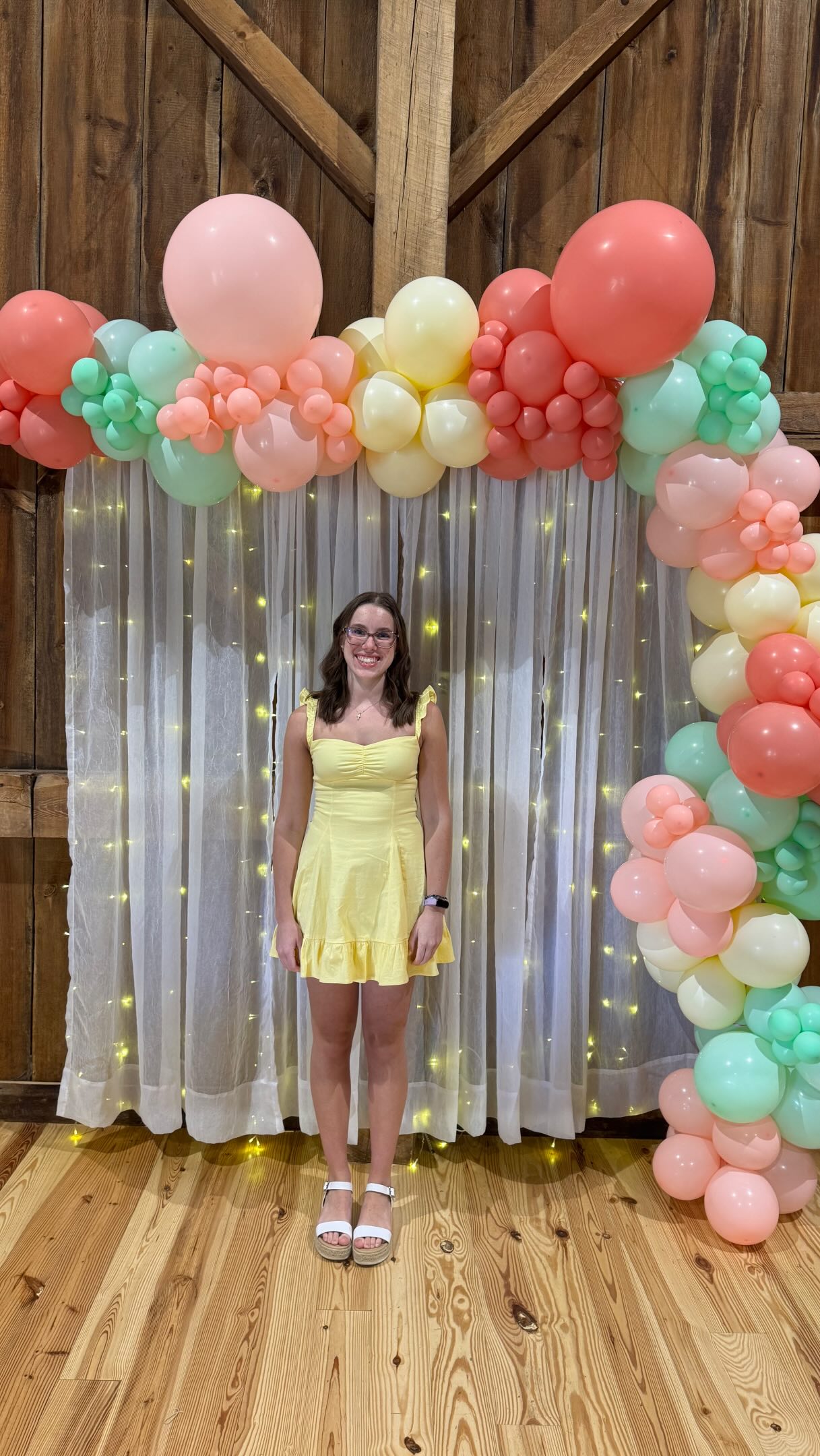 Pastel graduation balloon arch paired with floral arrangements